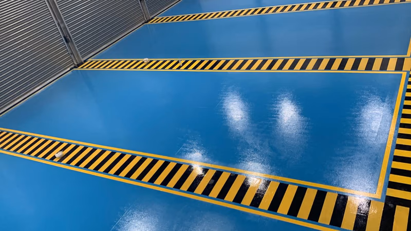 2MIC : Bandes de danger noires et jaunes sur sol époxy bleu