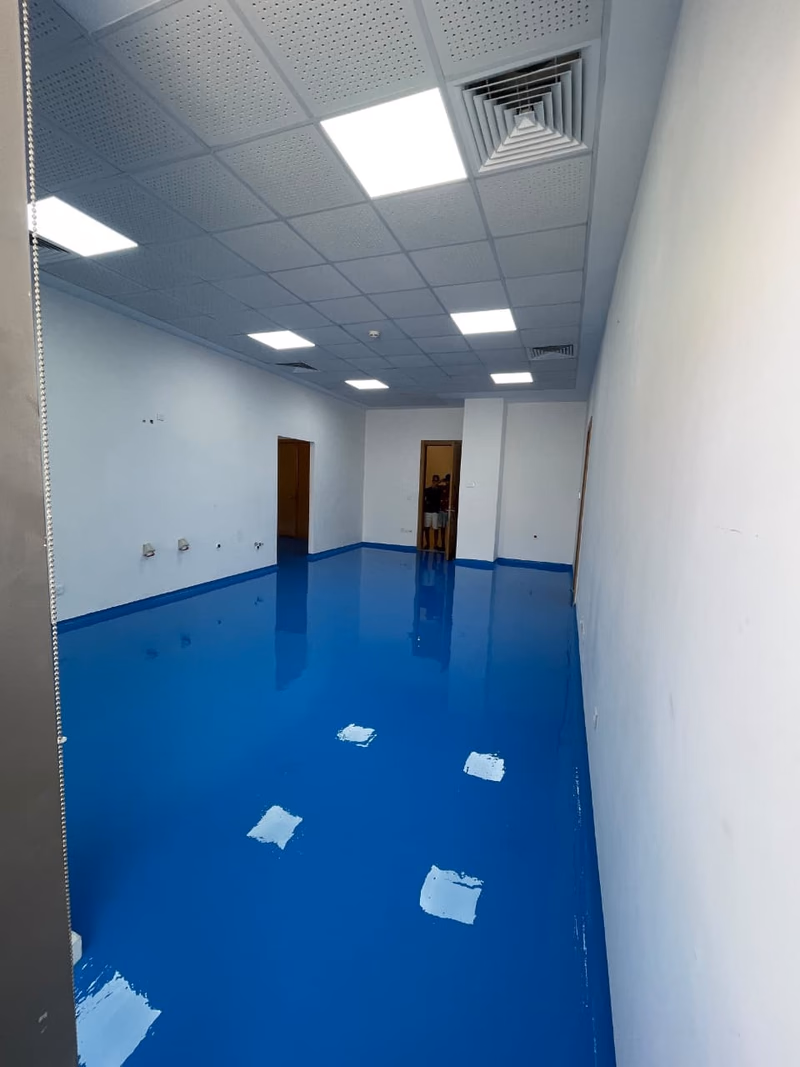 Fondation Lalla Asmaa : Salle aux murs blancs et au sol époxy bleu