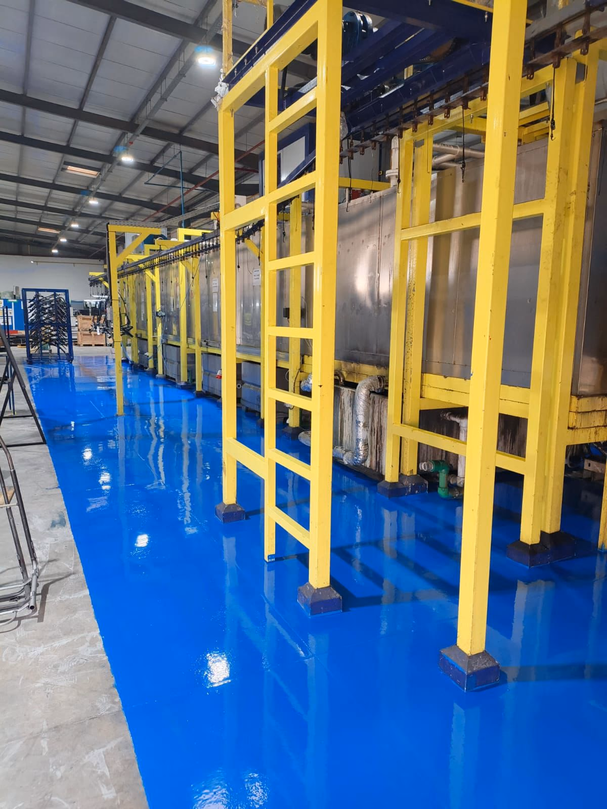 Micronitech : Sol époxy bleu brillant sous les structures jaunes de l'usine