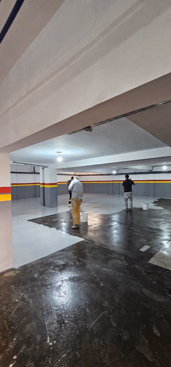 Application de la résine époxy grise dans un parking en sous-sol
