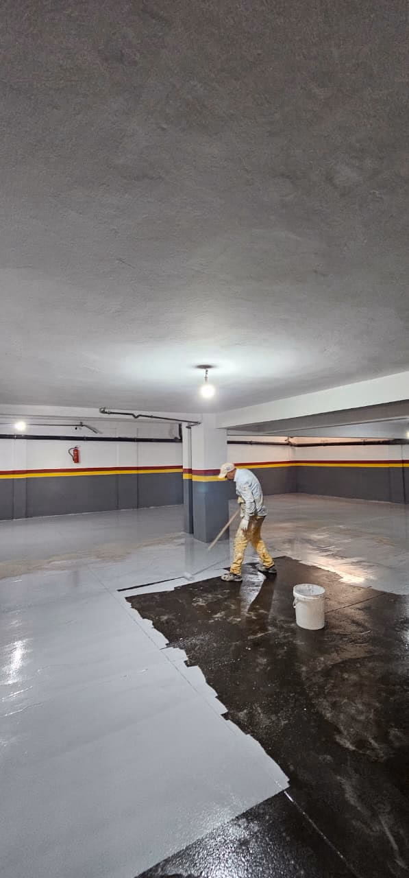 Applicateur passant la résine époxy dans un parking en sous-sol