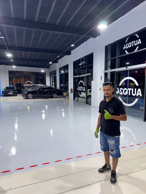 Technicien Sol Epoxy dans un showroom automobile après la pose du sol